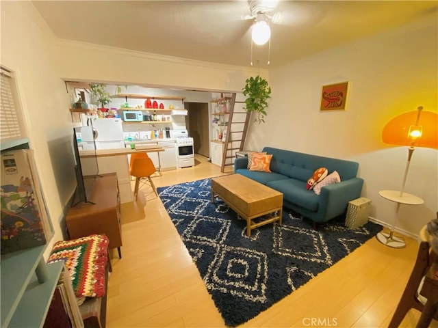 living room featuring ceiling fan, ornamental molding, and hardwood / wood-style flooring