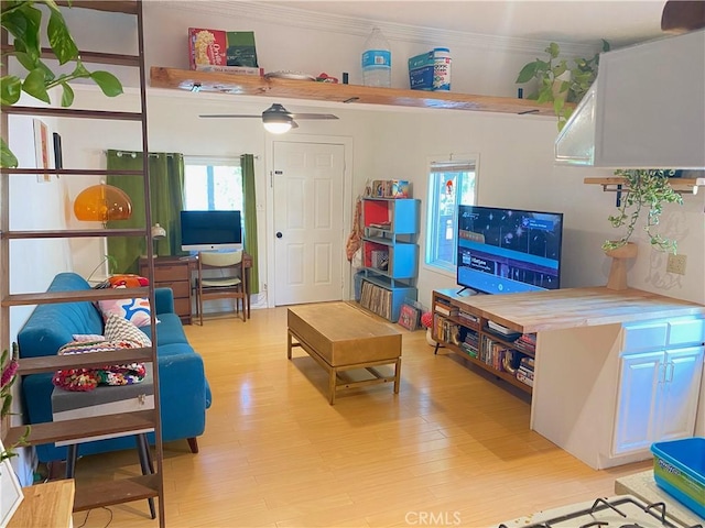 game room with ceiling fan, light hardwood / wood-style flooring, and ornamental molding