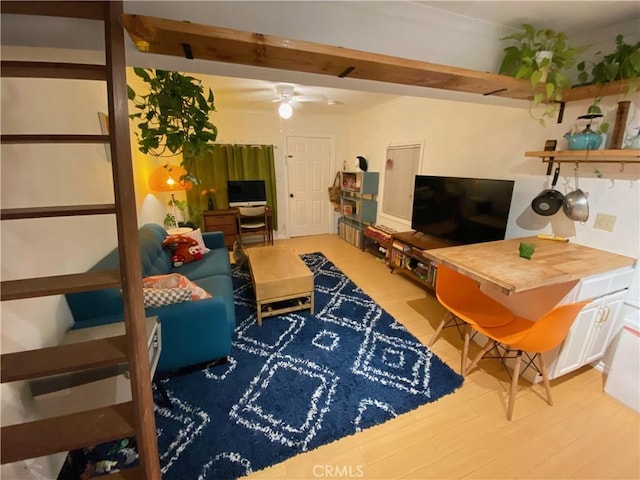 living room featuring beamed ceiling, ceiling fan, and wood-type flooring