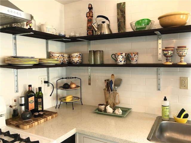 kitchen with range, backsplash, and sink