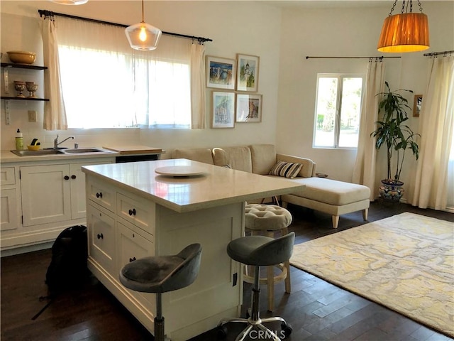 kitchen with white cabinets, decorative light fixtures, and a kitchen breakfast bar