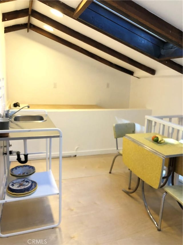 dining room with vaulted ceiling with beams and sink