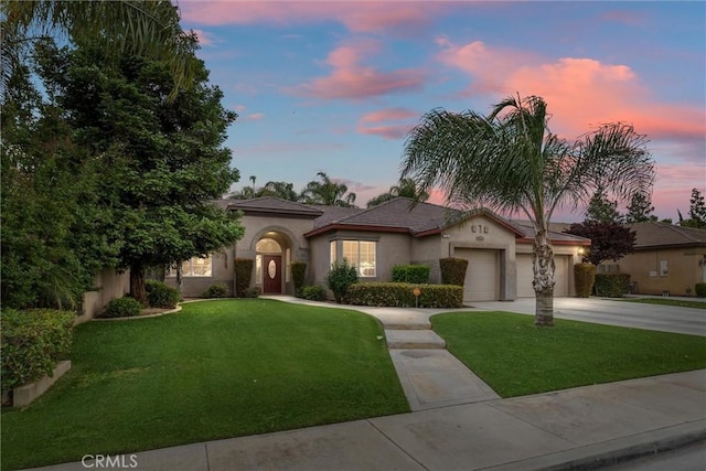 mediterranean / spanish-style house with a garage and a lawn