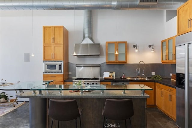 kitchen featuring tasteful backsplash, a breakfast bar, sink, built in appliances, and a center island