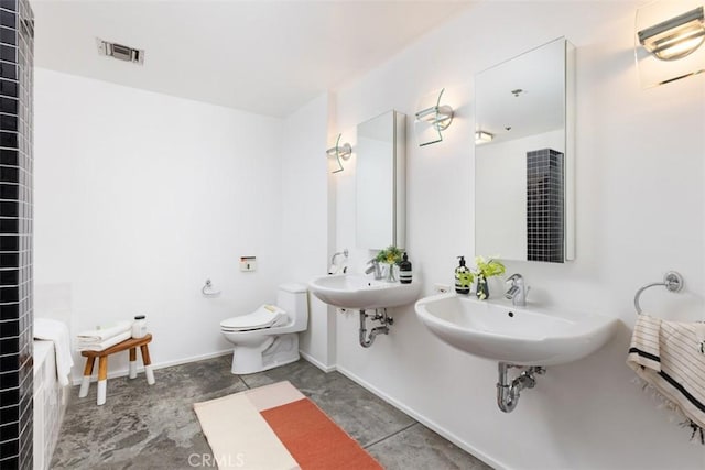 bathroom with toilet and double sink