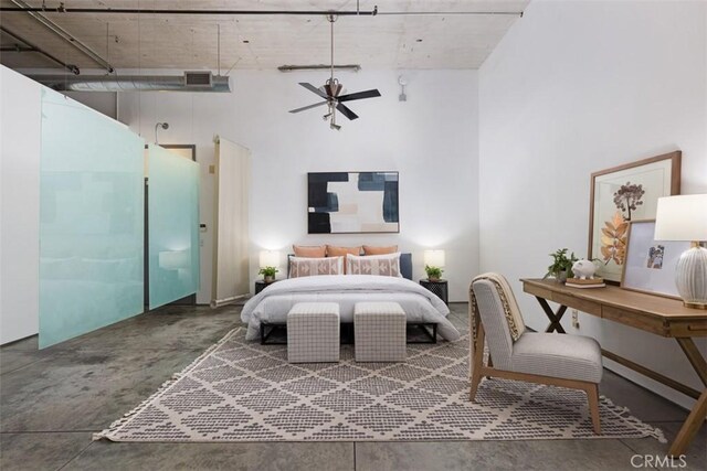 bedroom with concrete flooring and a high ceiling