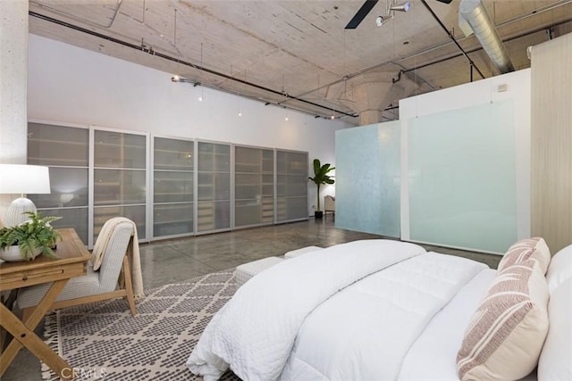 bedroom with ceiling fan and concrete flooring