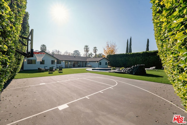 view of sport court with a yard