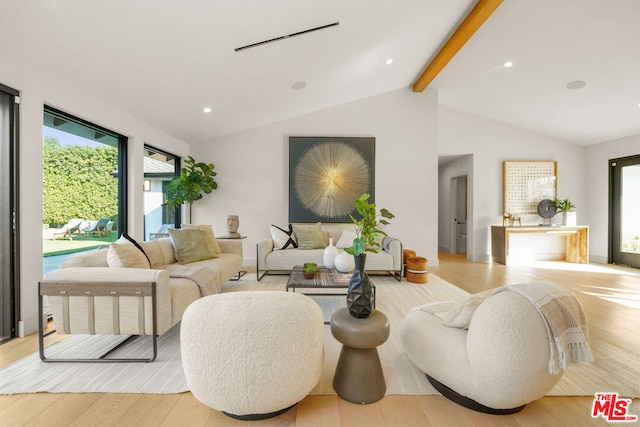 living room featuring vaulted ceiling with beams and light wood-type flooring