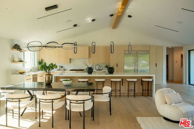 kitchen featuring a center island, light wood-type flooring, hanging light fixtures, and appliances with stainless steel finishes