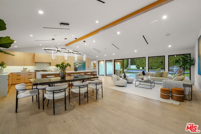 dining space with lofted ceiling with beams, expansive windows, and light hardwood / wood-style floors