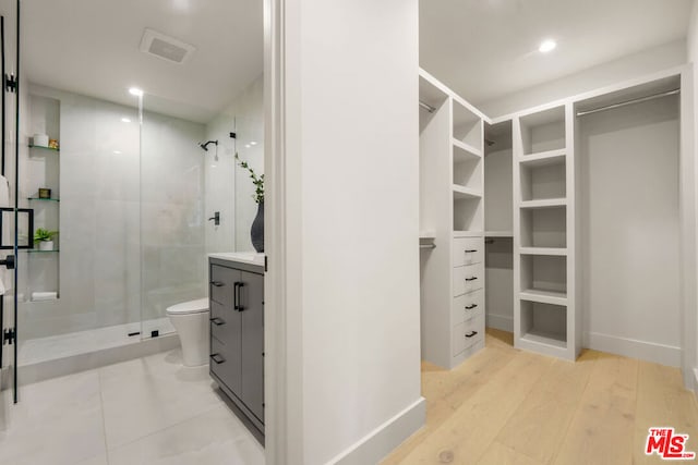 interior space with hardwood / wood-style floors, toilet, and walk in shower