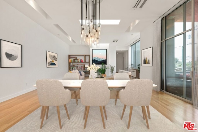 dining area featuring light hardwood / wood-style floors and an inviting chandelier