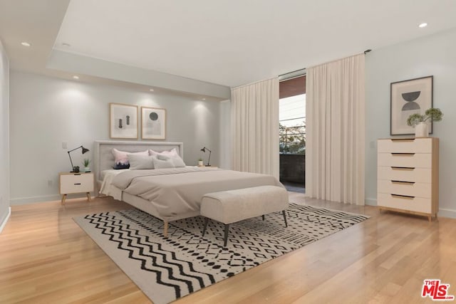 bedroom with access to exterior and light hardwood / wood-style flooring