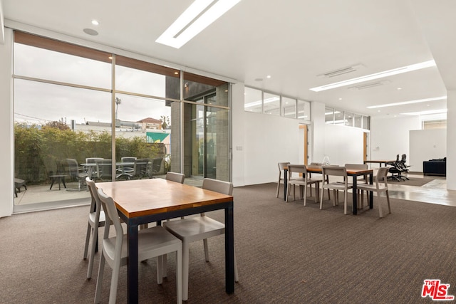 dining space featuring carpet flooring and expansive windows