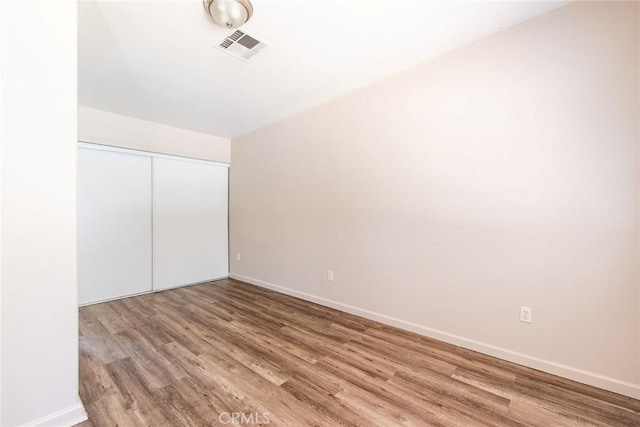 unfurnished bedroom featuring a closet and hardwood / wood-style floors