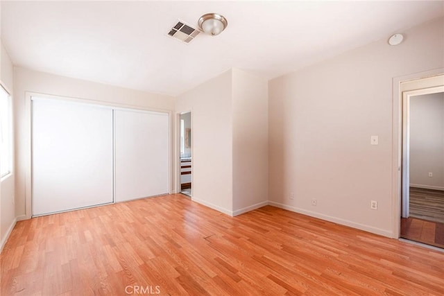 unfurnished bedroom featuring light hardwood / wood-style floors and a closet