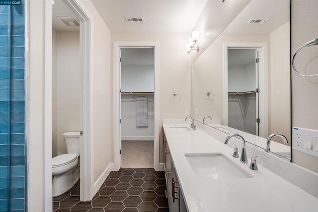 bathroom featuring vanity, tile patterned floors, and toilet