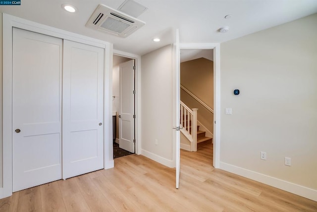 unfurnished bedroom featuring a closet and light hardwood / wood-style flooring