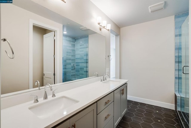 bathroom with a shower with door, vanity, and tile patterned floors