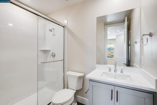 bathroom featuring a shower with door, vanity, and toilet