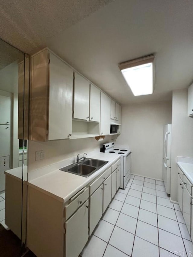 kitchen with sink, white cabinets, white appliances, and light tile patterned floors