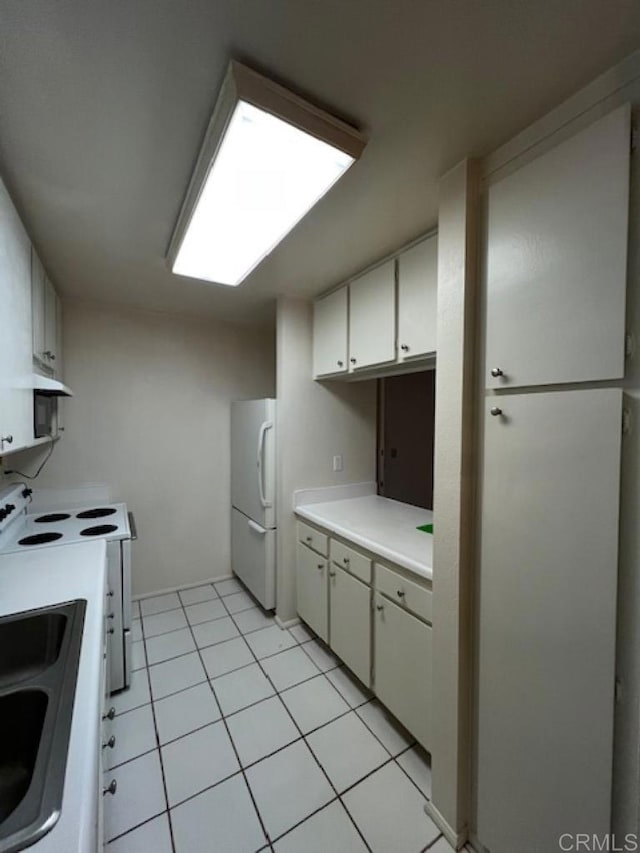 kitchen featuring white cabinetry, light tile patterned floors, and white appliances