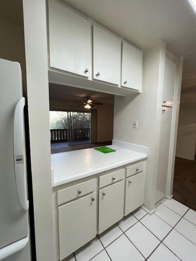 kitchen with white cabinets, ceiling fan, light tile patterned floors, and fridge