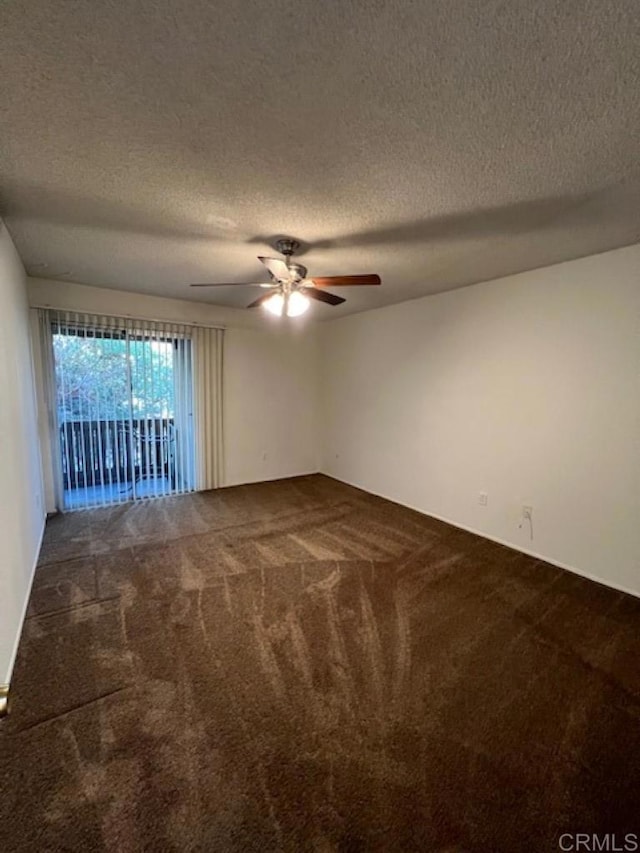 carpeted spare room featuring ceiling fan and a textured ceiling