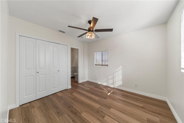 unfurnished bedroom featuring wood-type flooring, a closet, and ceiling fan