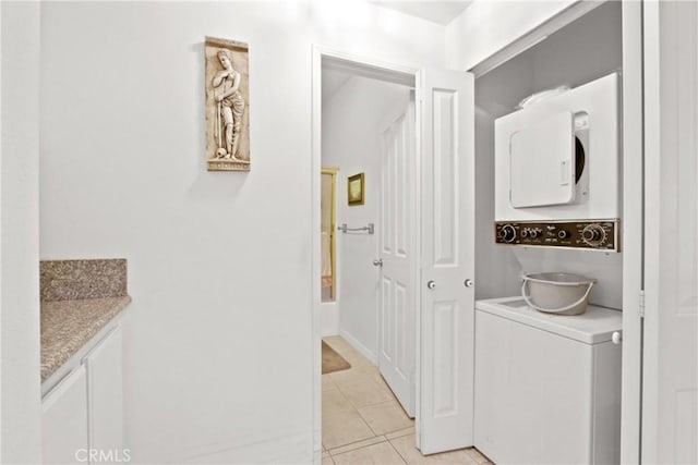 bathroom with tile patterned floors, vanity, and stacked washer and clothes dryer