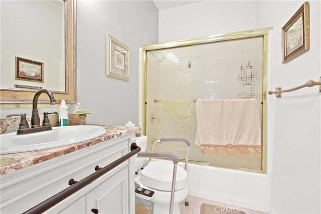 full bathroom featuring tile patterned flooring, vanity, toilet, and bath / shower combo with glass door