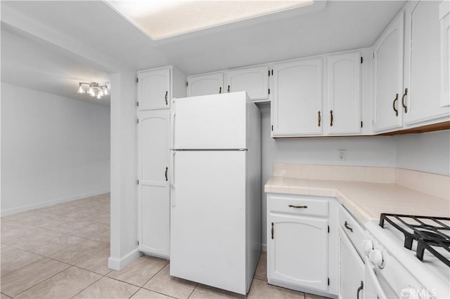 kitchen featuring white cabinetry, light tile patterned flooring, and white appliances