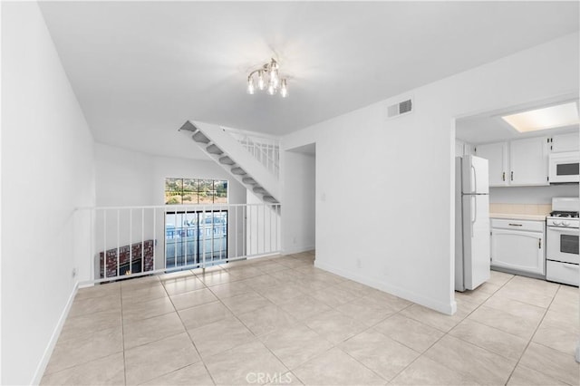 unfurnished living room with light tile patterned floors and a notable chandelier