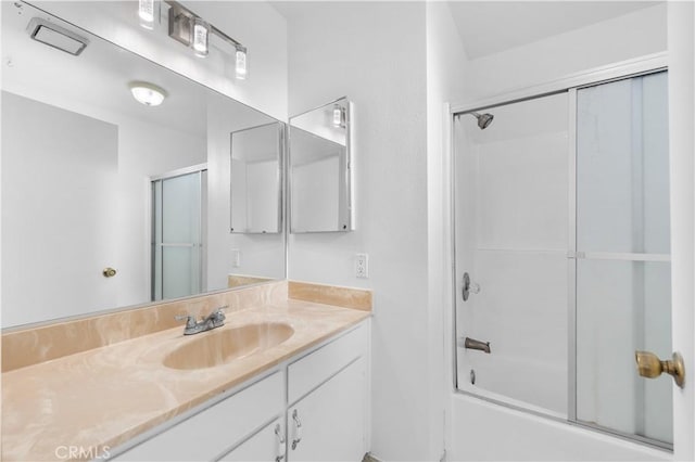 bathroom with vanity and combined bath / shower with glass door