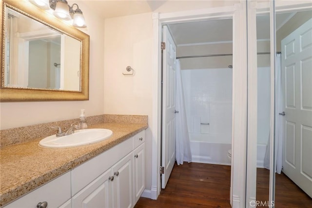 full bathroom featuring vanity, hardwood / wood-style flooring, toilet, and shower / bathtub combination with curtain