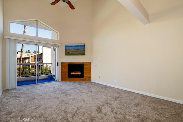 unfurnished living room featuring carpet floors, ceiling fan, and high vaulted ceiling