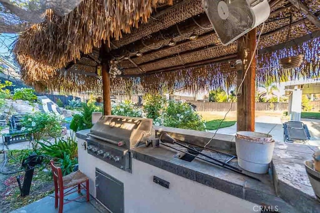 view of patio / terrace featuring a gazebo, exterior kitchen, and grilling area