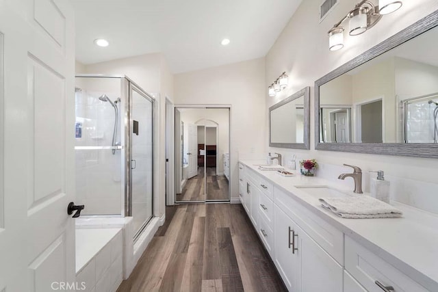 bathroom with vanity, plus walk in shower, vaulted ceiling, and hardwood / wood-style flooring