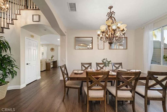 dining space featuring dark hardwood / wood-style flooring and an inviting chandelier