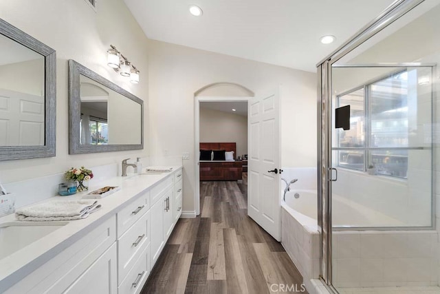 bathroom featuring hardwood / wood-style floors, vanity, a healthy amount of sunlight, and vaulted ceiling