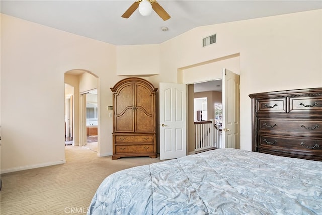 carpeted bedroom featuring ceiling fan, ensuite bathroom, and vaulted ceiling