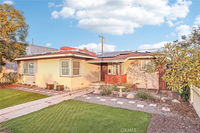 view of front of home featuring solar panels and a front lawn