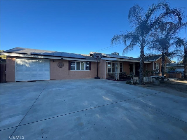 single story home featuring solar panels and a garage