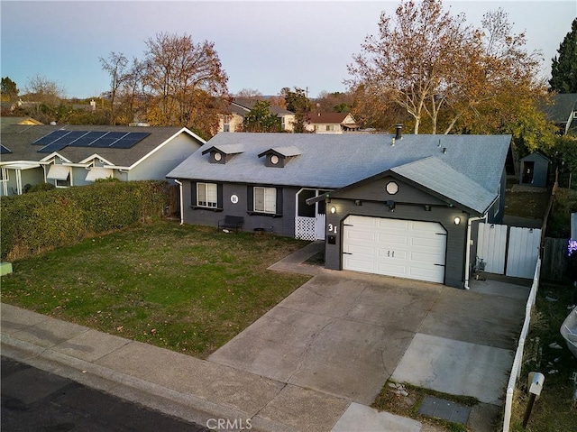 ranch-style house featuring a garage and a front lawn