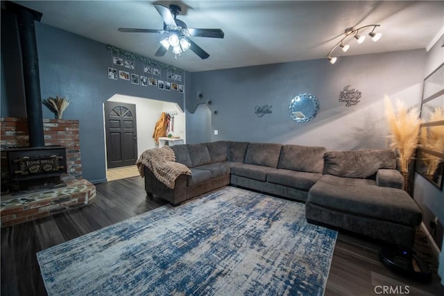 living room with a wood stove, ceiling fan, and hardwood / wood-style floors