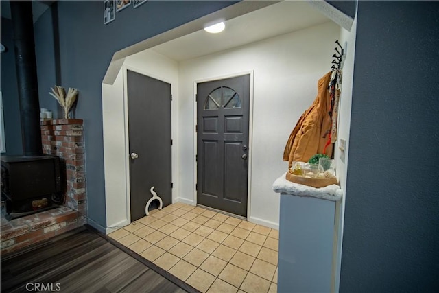 entryway with a wood stove and light hardwood / wood-style flooring