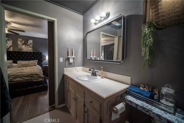 bathroom with ceiling fan, vanity, and crown molding