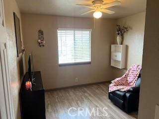 sitting room with ceiling fan and light wood-type flooring