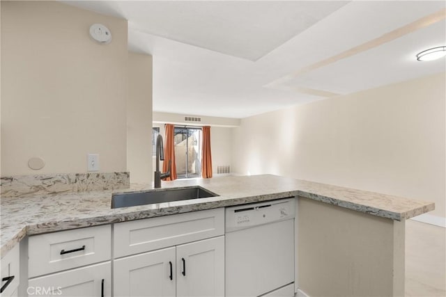 kitchen with dishwasher, white cabinets, sink, light stone countertops, and kitchen peninsula